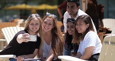 Five Waterloo students posing for a selfie outside