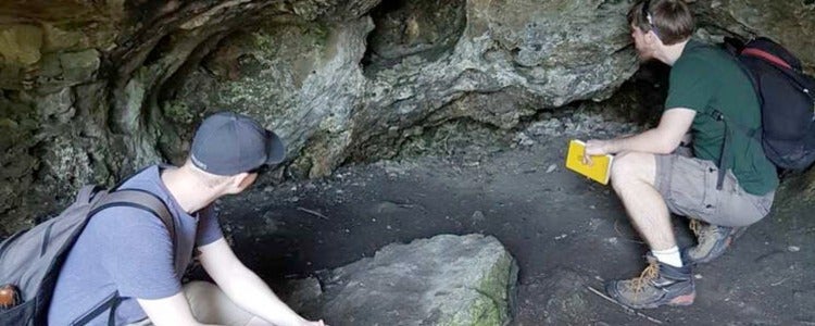 Students looking in a cave.