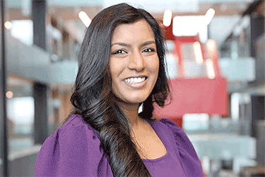 Management Engineering graduate Thevany wearing a purple shirt looking and smiling at the camera