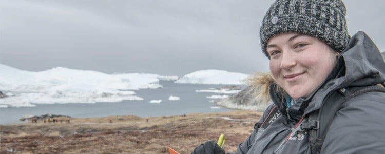 Cassandra taking field notes in front of Arctic glaciers and sea ice