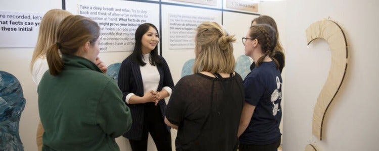 Victoria discusses her team's exhibit with a group of visitors