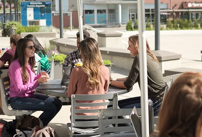 Students sitting outside on a patio and conversating.