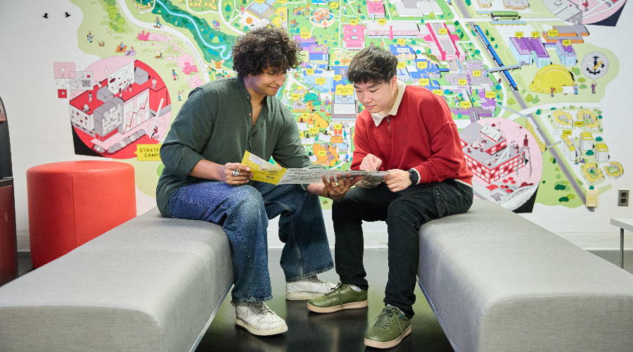 Two students look at a viewbook in the Visitor's Centre