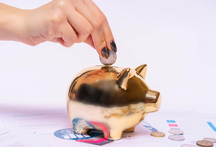 coin being put into a piggy bank