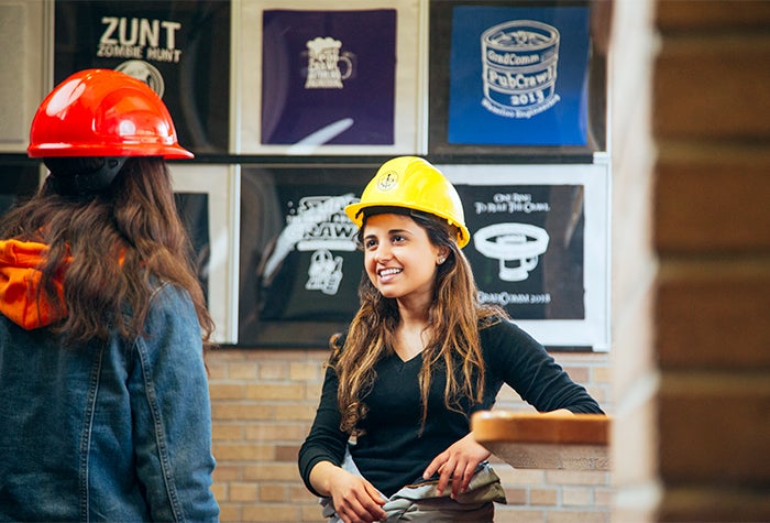 two women in hard hats talking to each other