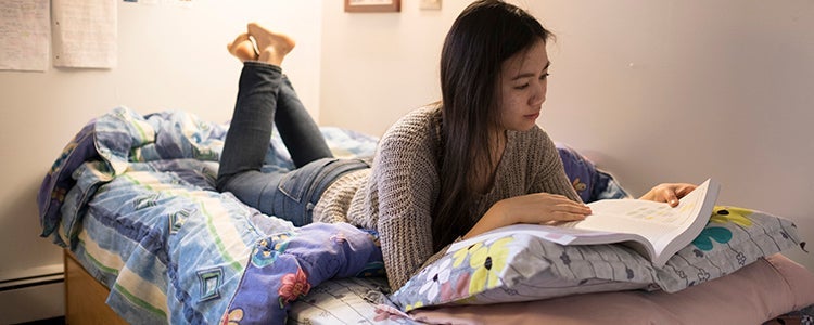 Student studying on their bed