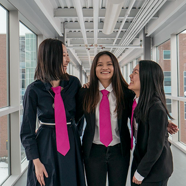 3 women with pink ties and blazers