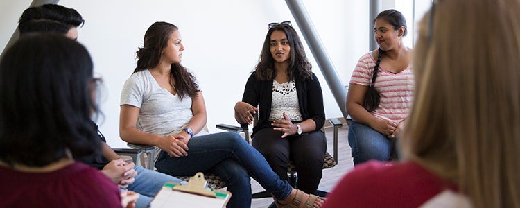 A group of students sitting together in a brightly lit room.