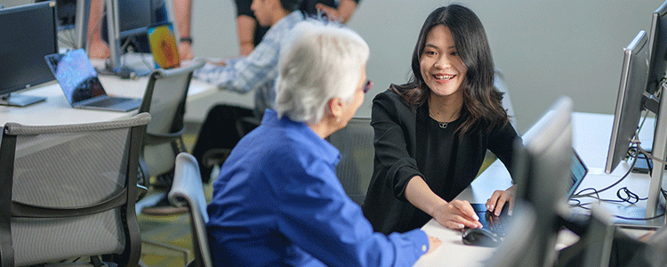 A professional conversing with a client in a computer lab