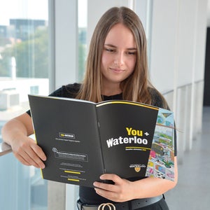 A student reads the University of Waterloo's viewbook