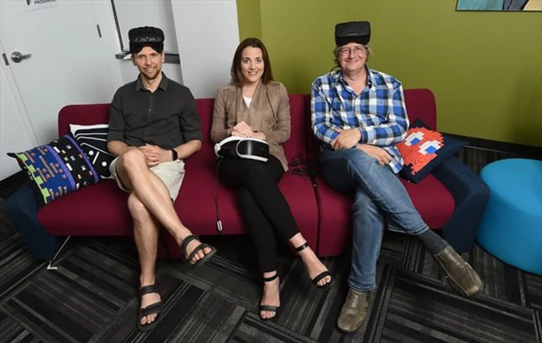 Mark, Kristina, and Neil sitting on a couch at the GI wearing VR headsets