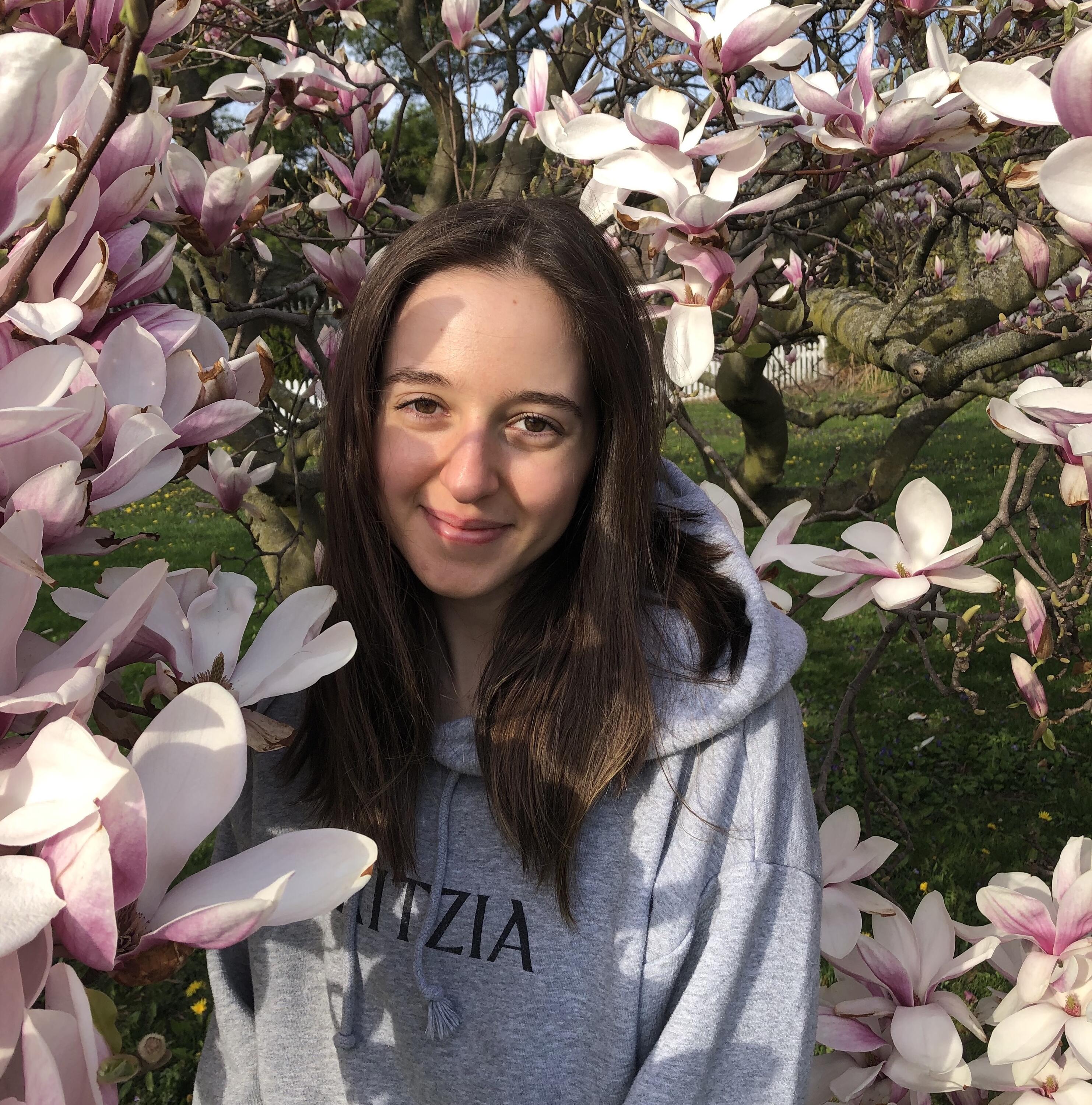 Arielle standing beside a magnolia tree
