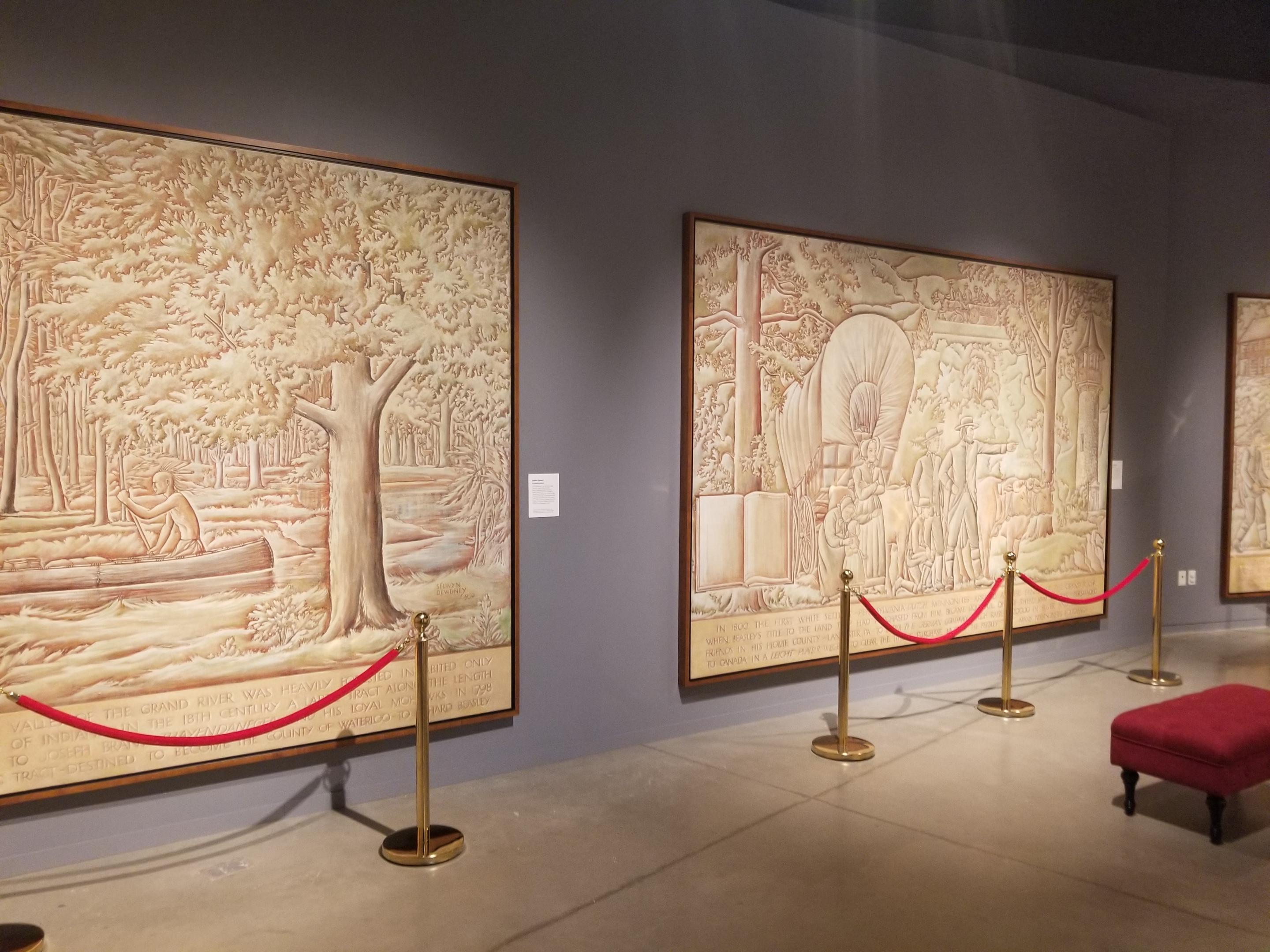 A series of murals painted by Selwyn Dewdney in 1950. The murals are two shades of brown and depict a man in a canoe and a family with a covered wagon