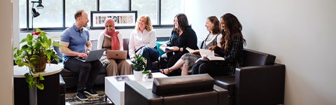 Diana Parry and five lab members having discussion in the department lounge.