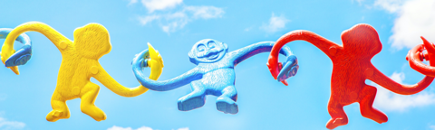 barrel of monkey's (toy) clasping hands against a blue sky