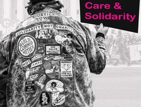 jean jacket covered in patches, protest in the background