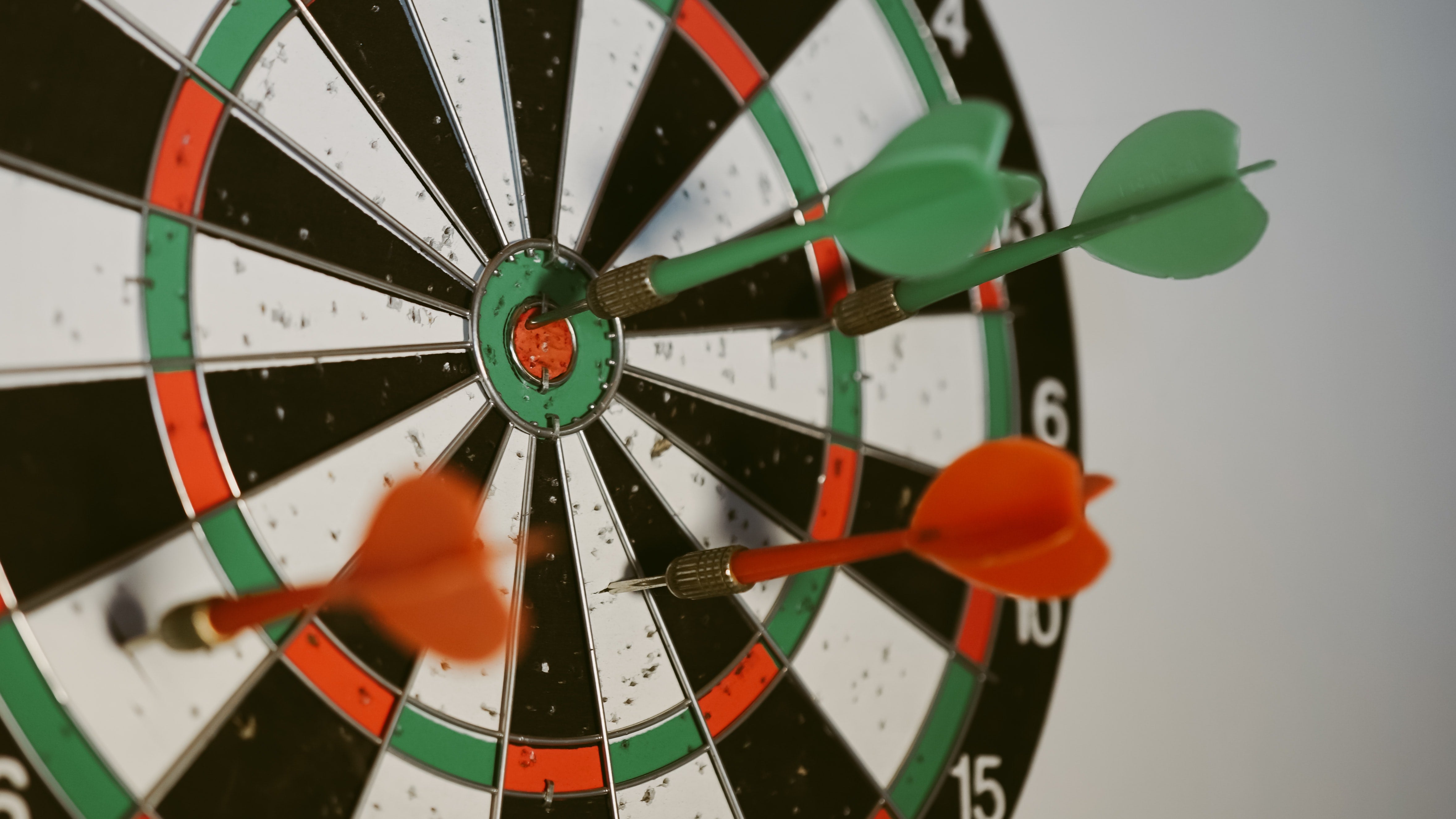 darts embedded in a dart board- one bull's eye