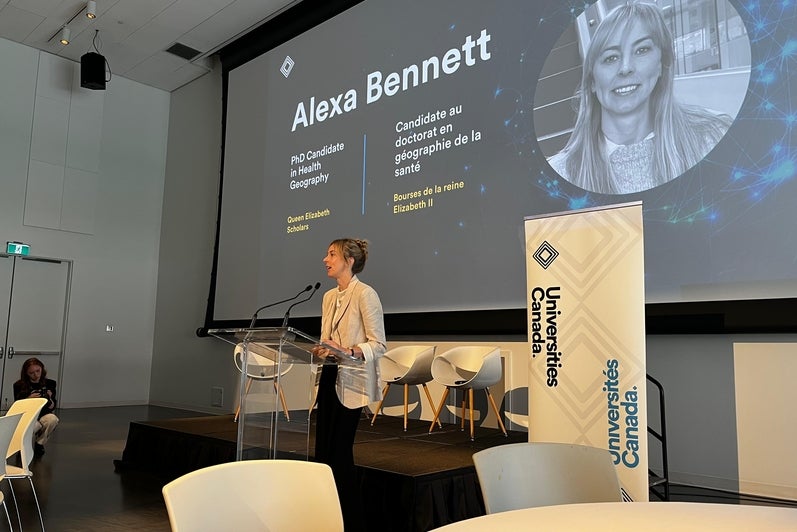 alexa standing at podium delivering keynote speech