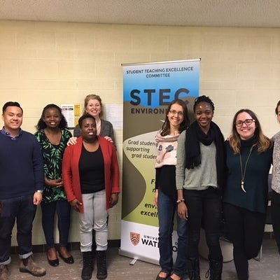 GoHelP lab members stand together in front of a Student Teaching Excellence Comittee banner