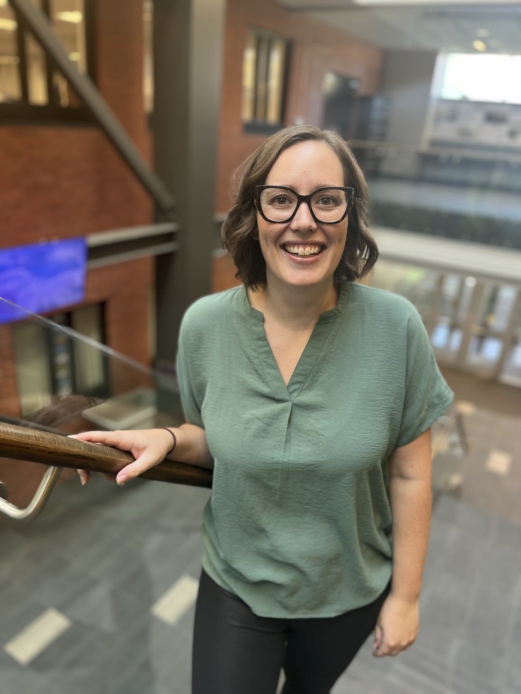 Keely standing in stairwell smiling at camera