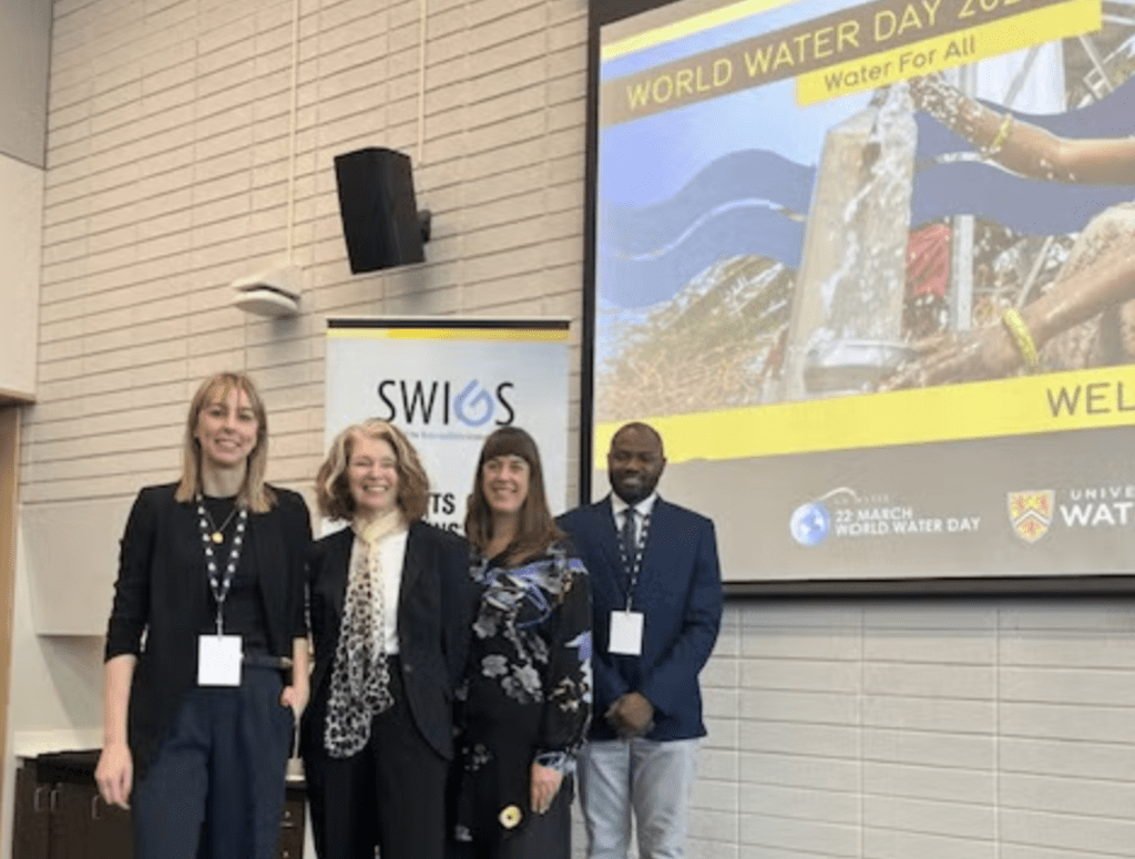 susan with members of gohelp lab standing in front of SWIGS world water day powerpoint presentation