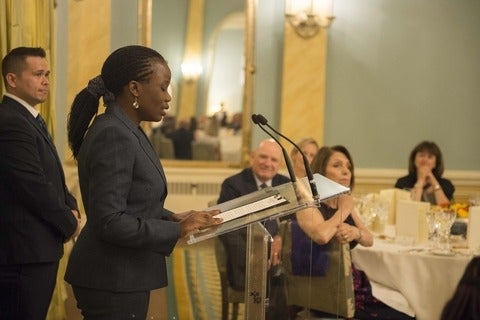 Elizabeth Opiyo standing at a podium delivering a speech