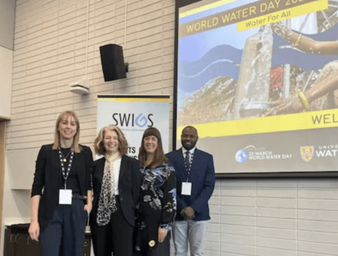 susan with members of gohelp lab standing in front of SWIGS world water day powerpoint presentation