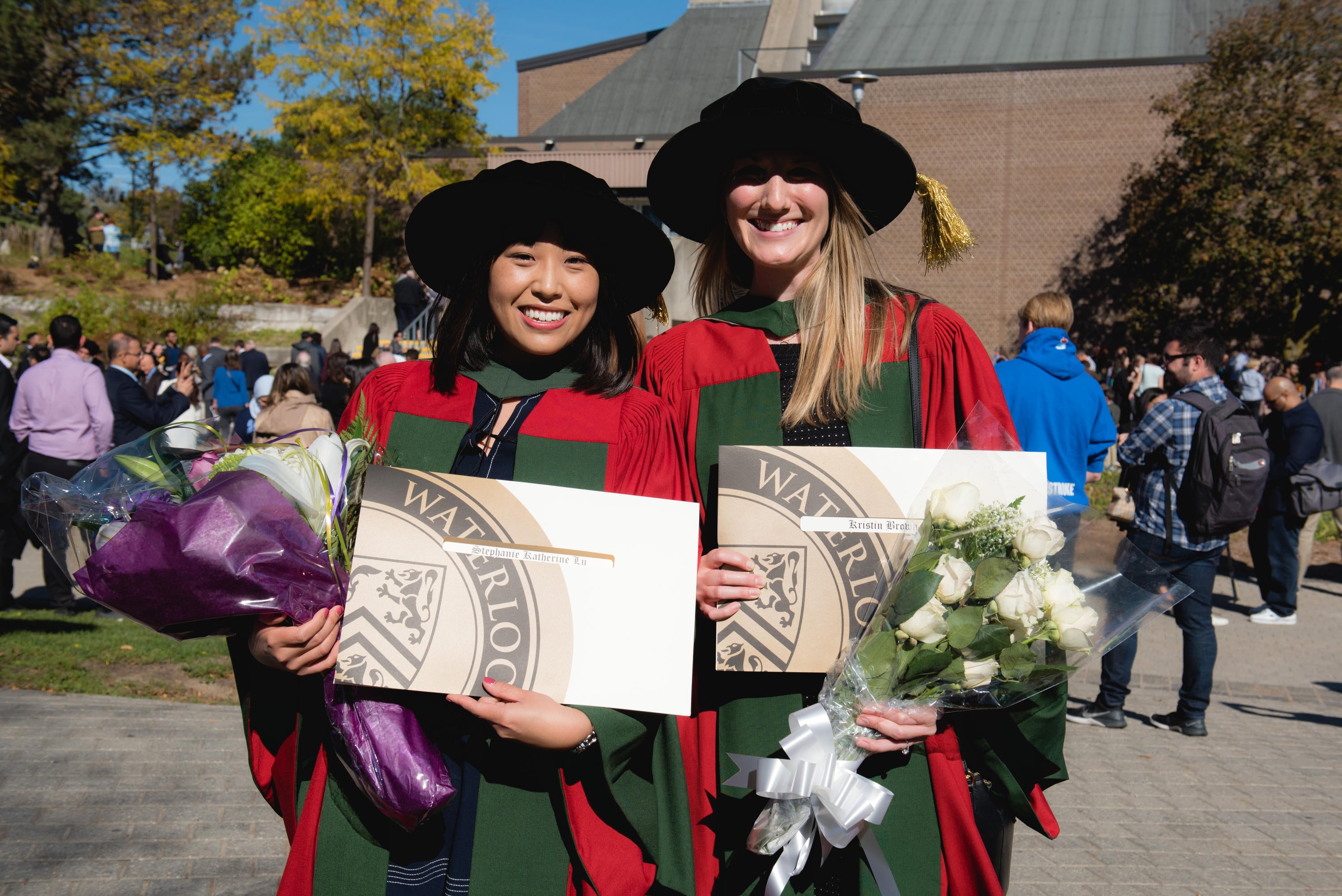 Dr. Stephanie Lu and Dr. Kristin Brown wearing gowns and hats at convocation