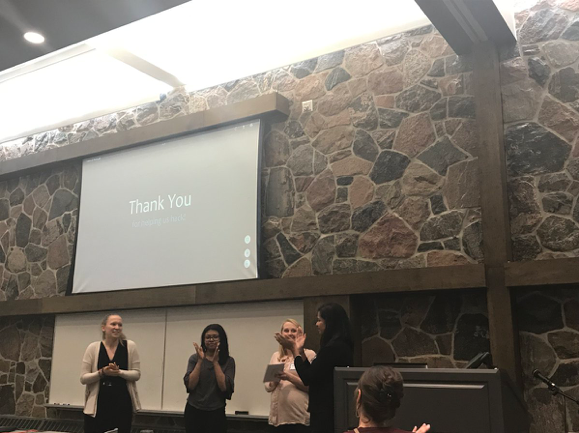 Hackathon organizers and speakers clap at the conclusion of the event