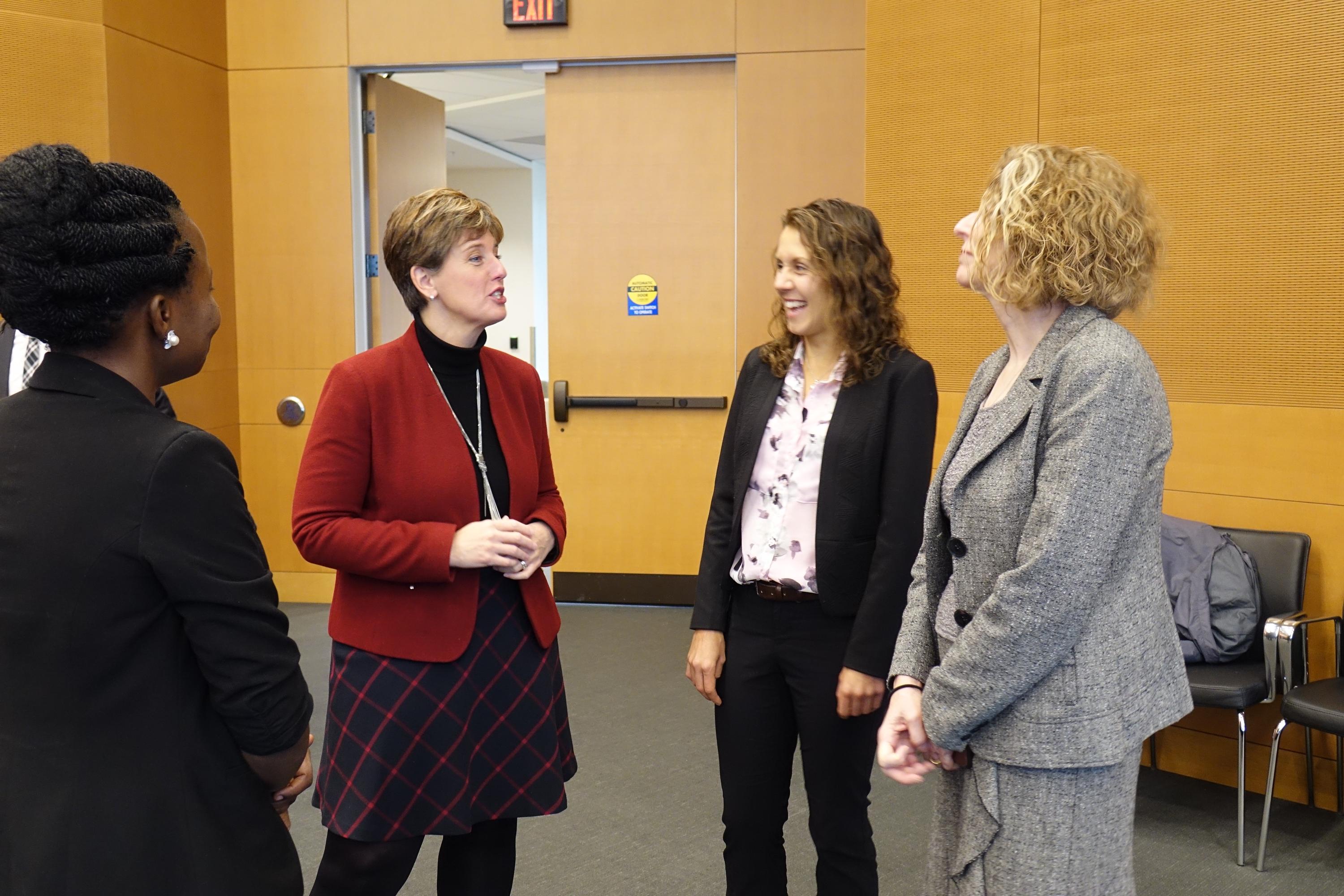 Elizabeth, Dr. Elliott, and Andrea Rishworth interact with the Minister of International Development