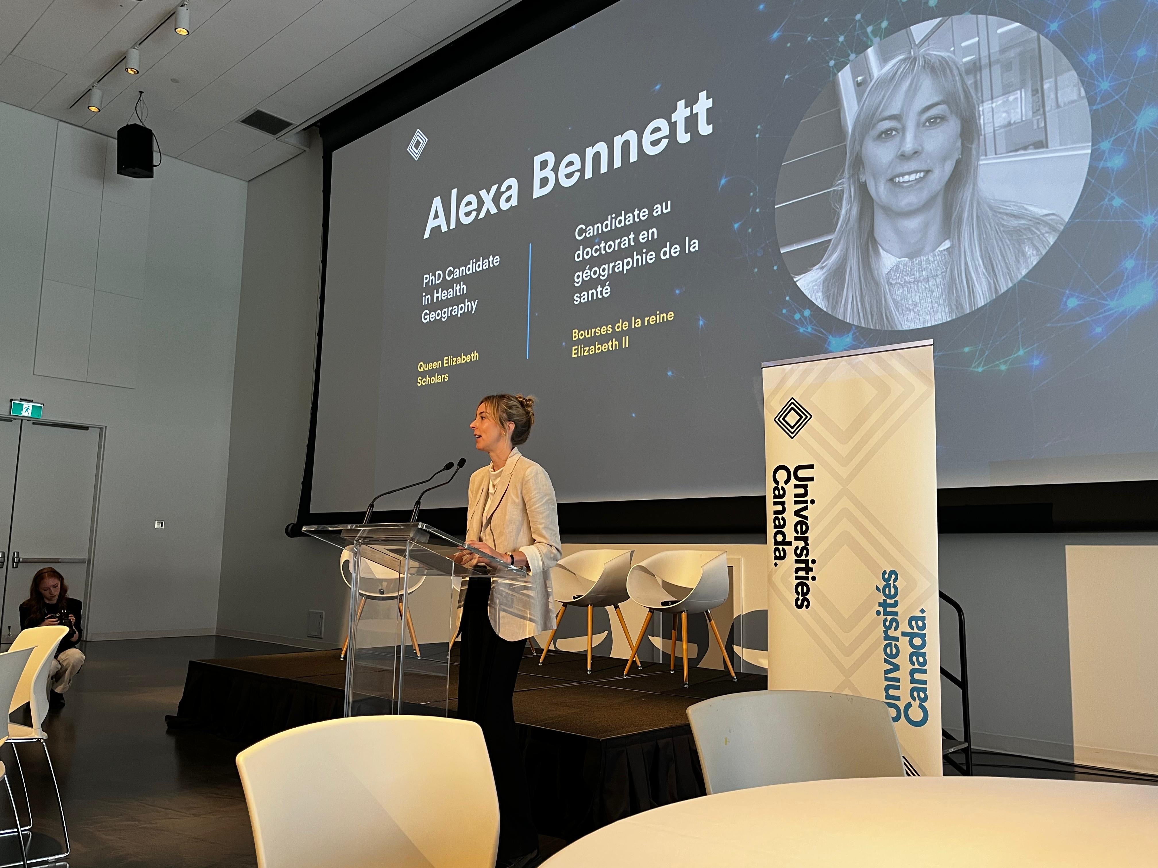 alexa standing at podium delivering keynote speech