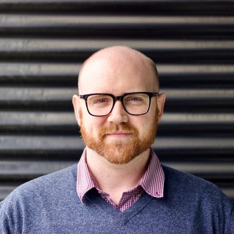 Peter Crank in front of a wall, looking at the camera