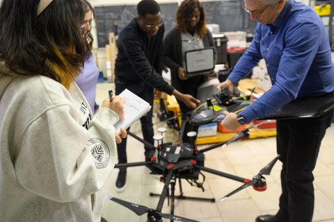 Claude and students working on a drone