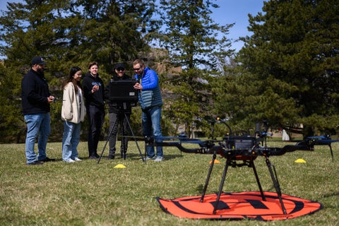 Students in a field with a drone
