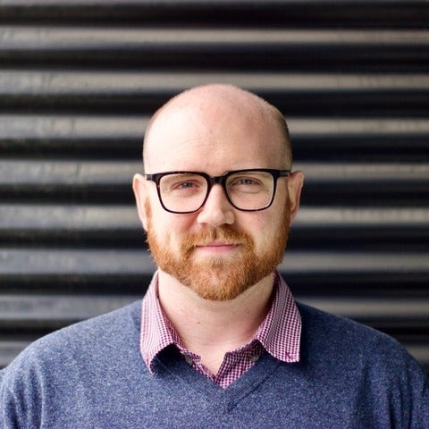 Peter Crank in front of a wall, looking at the camera