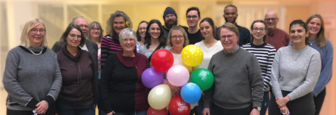 GSS staff posing together next to balloons