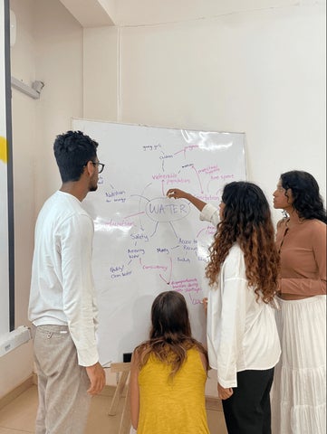students collaborating on a whiteboard 
