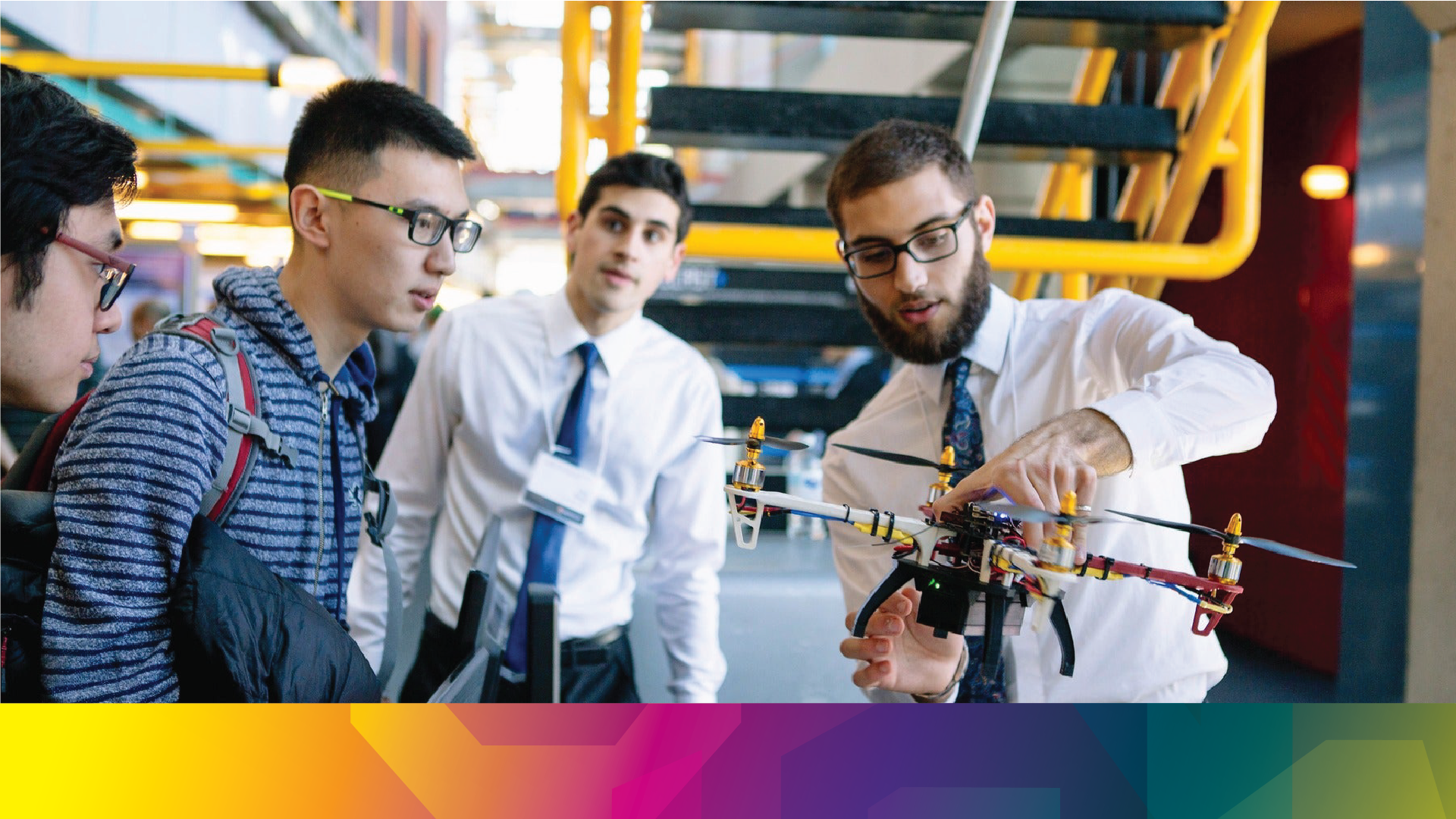 A group of students looking a drone one of the students is holding