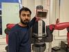 Ali Ayub standing by a robot