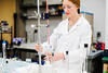 A student in a lab coat conducts an experiment