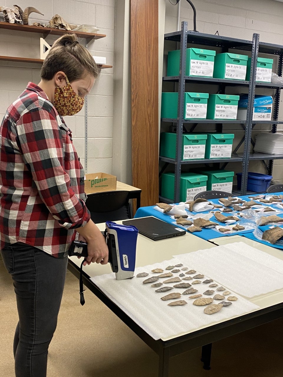 Student in a lab examining artifacts