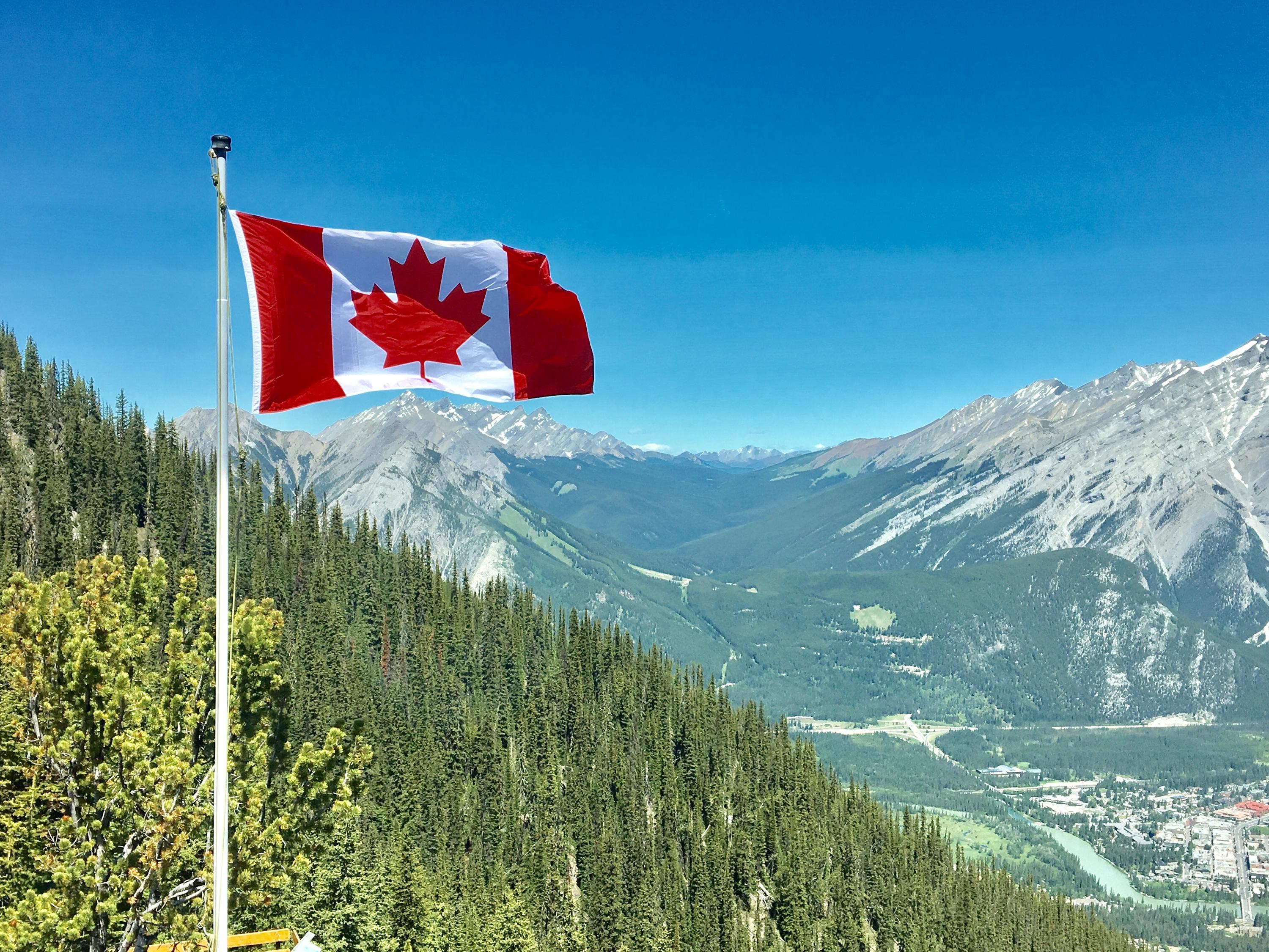 Canada flag in front of mountains 