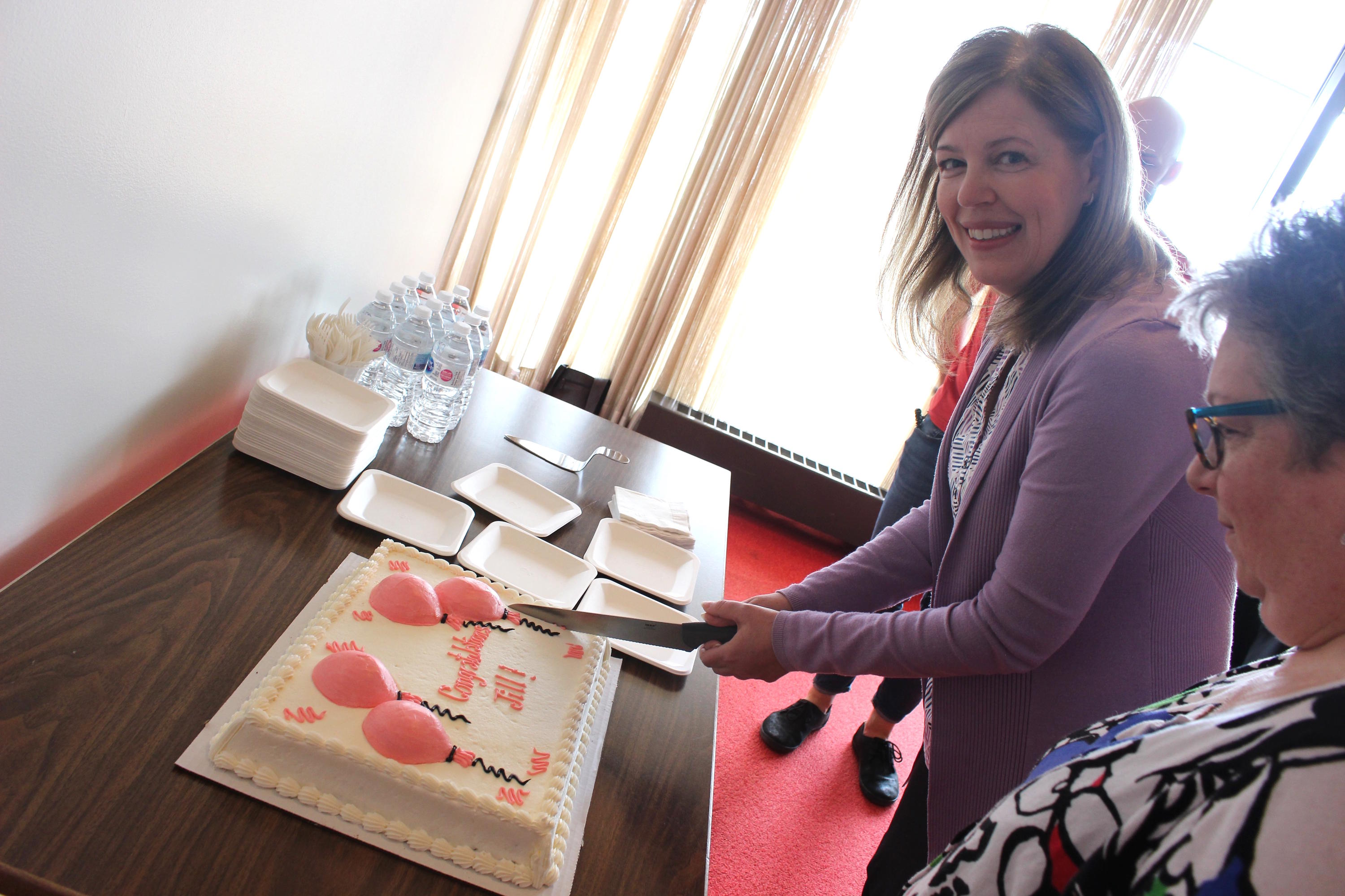 photo of Dr. Jill Woods cutting her celebratory cake