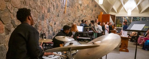 A drummer plays at a drumset during a chapel choir concert in the Grebel chapel