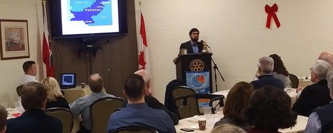 A grad, Rizwan, student speaks to a crowd of Rotary members