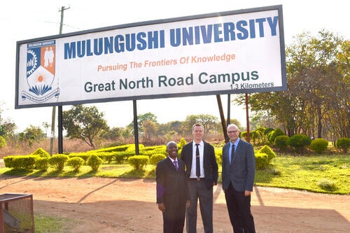 Rod and colleagues stand outside a Mulungushi University sign
