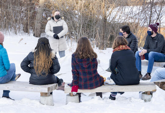 Students sitting outside for a Chapel service in the snow