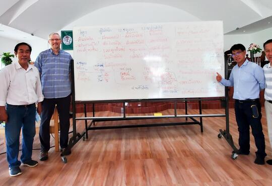 Derek Suderman alongside church leaders in Thailand in front of large whiteboard