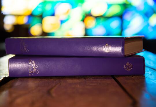 Two purple songbooks stacked on table in Grebel Chapel