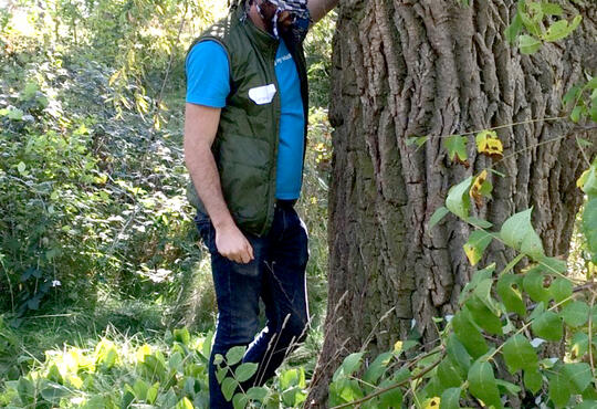 Jeremy Spira stands in front of a willow tree, blind folded, and reach out to touch it